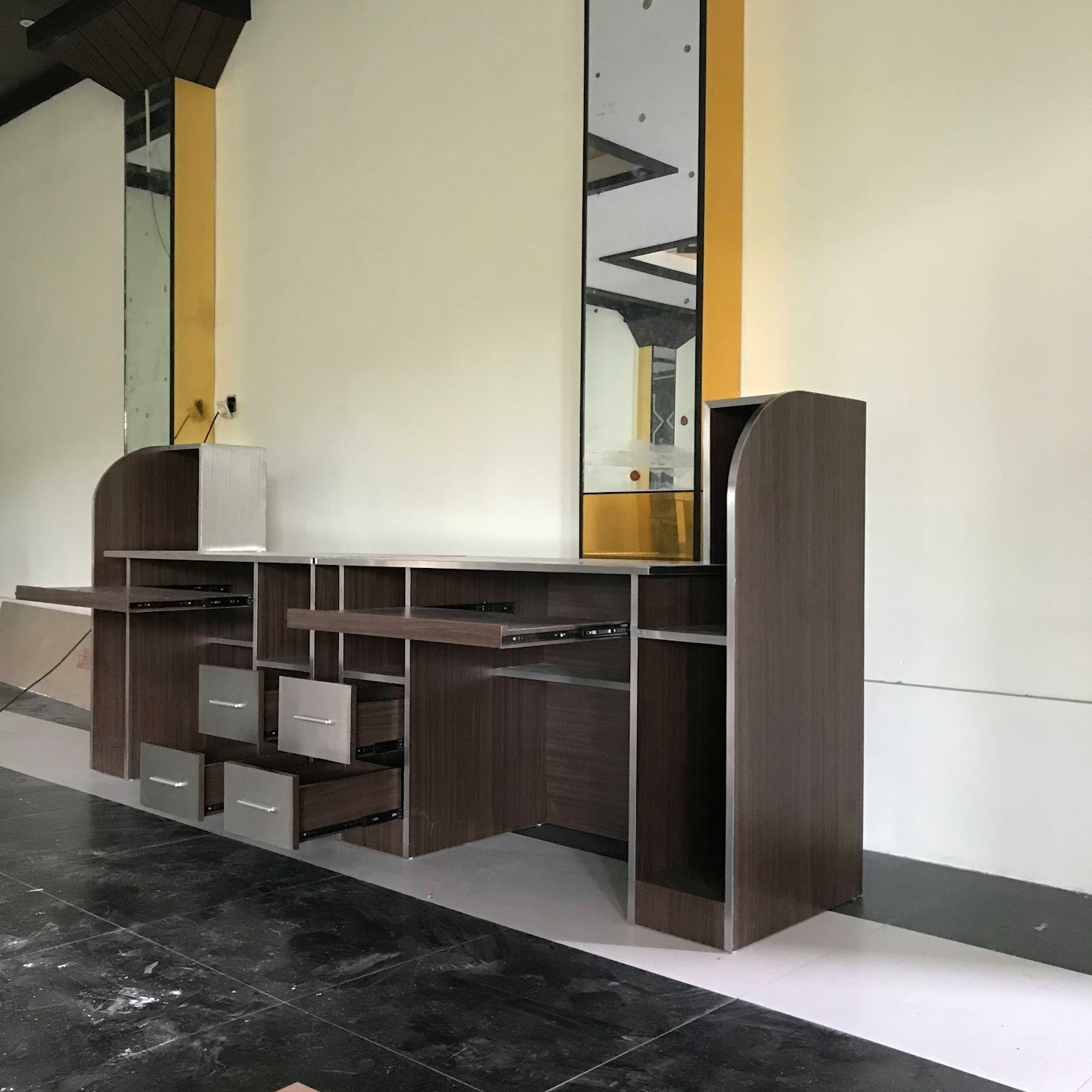 Modern office workstation with open drawers stands in a tiled room.