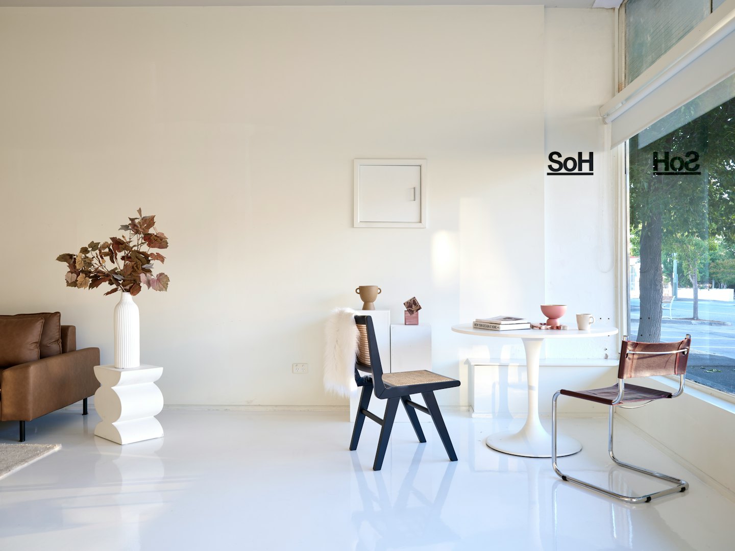 Modern office lobby featuring mid-century furniture and large windows.